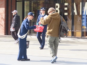 リーフレットを配布して密輸情報提供を呼び掛けている職員