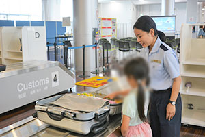 スーツケースから模擬麻薬などを探す小学生 スーツケースから模擬麻薬などを探す小学生