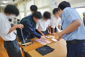 実物の知的財産侵害物品を手に取る生徒たち 実物の知的財産侵害物品を手に取る生徒たち