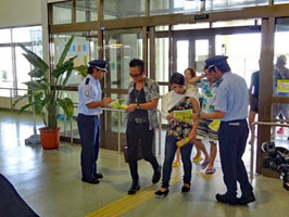 ターミナルビル内の出入口でチラシを配る税関職員