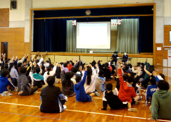 質問で手を挙げるたくさんの児童達 質問で手を挙げるたくさんの児童達