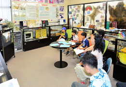 広報展示室でDVDを視聴する見学者ら 広報展示室でDVDを視聴する見学者ら