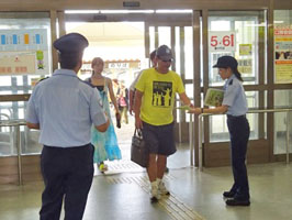 ターミナルビル内の出入口でチラシを配る税関職員 ターミナルビル内の出入口でチラシを配る税関職員