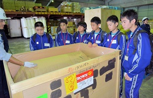 実際の荷物で説明を聞く中学生ら 実際の荷物で説明を聞く中学生ら