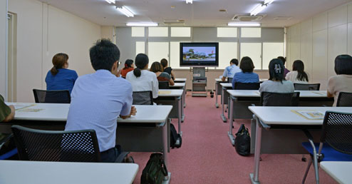 広報ビデオ視聴中の見学者ら 広報ビデオ視聴中の見学者ら